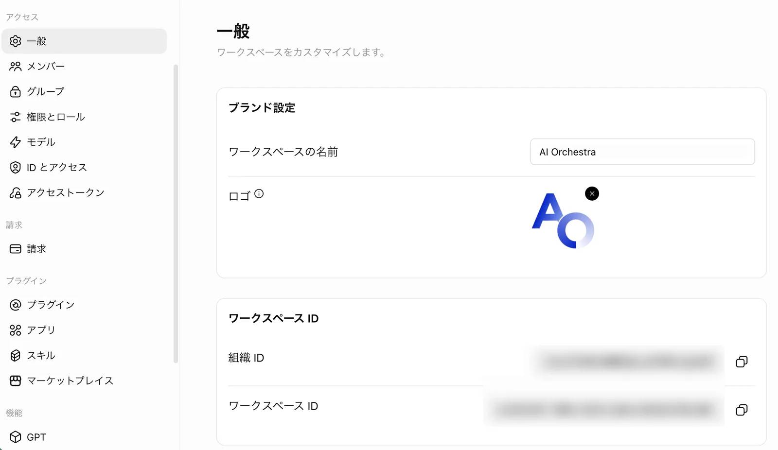 ワークスペースの設定の「一般」画面。左メニューにアクセス・請求・プラグイン・機能のグループが並び、右側にブランド設定(ワークスペースの名前 AI Orchestra・ロゴ)とワークスペースID(組織ID・ワークスペースID)のカードがある